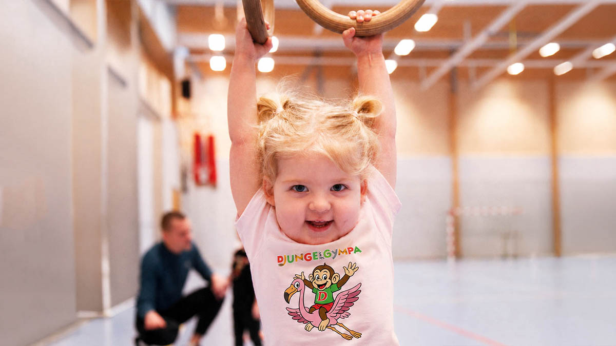 Glatt barn hänger i ringar på Djungelgympa